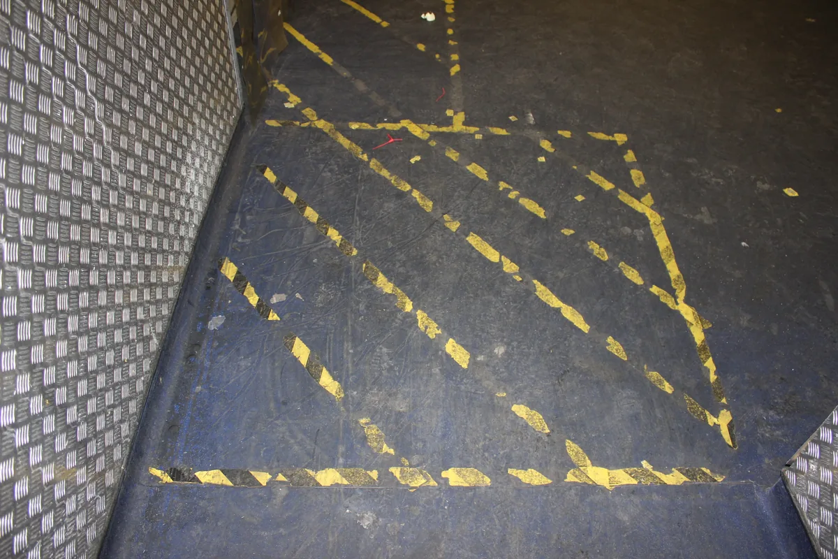 Yellow floor hatching dulled by soil before the clean