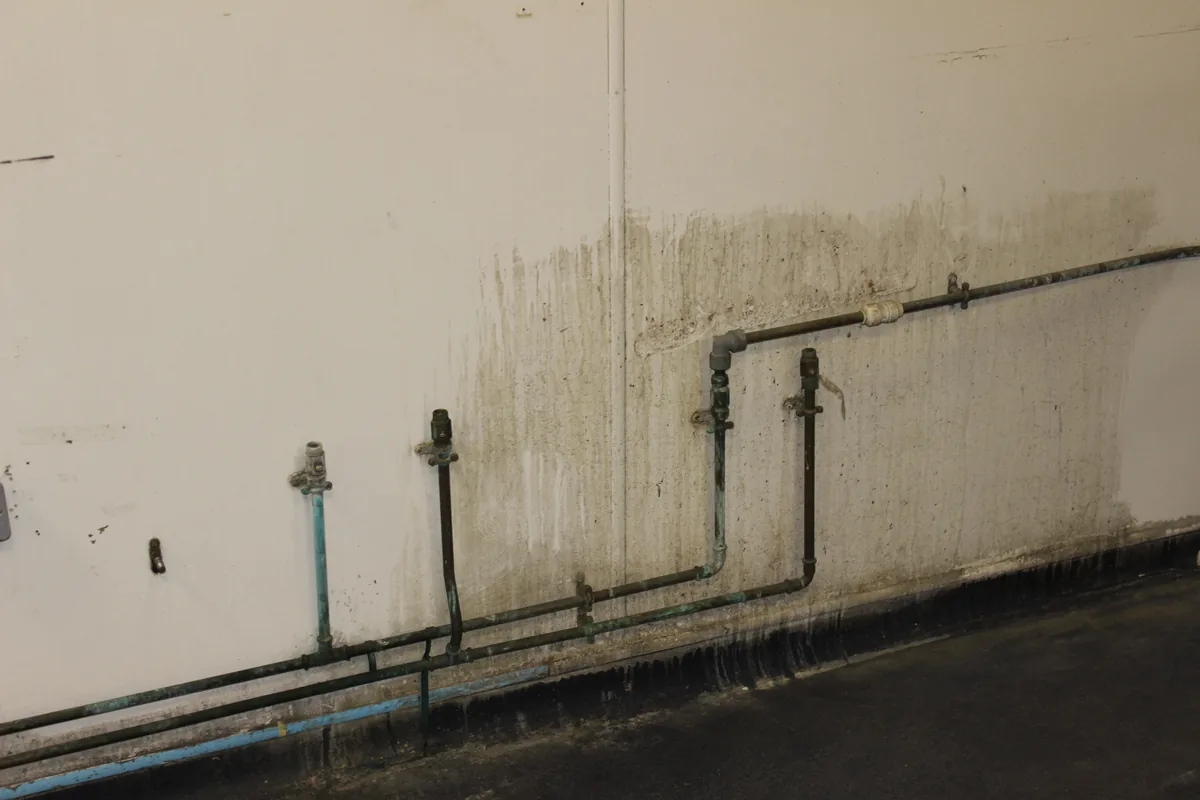 A store wall heavily stained along its length before the clean